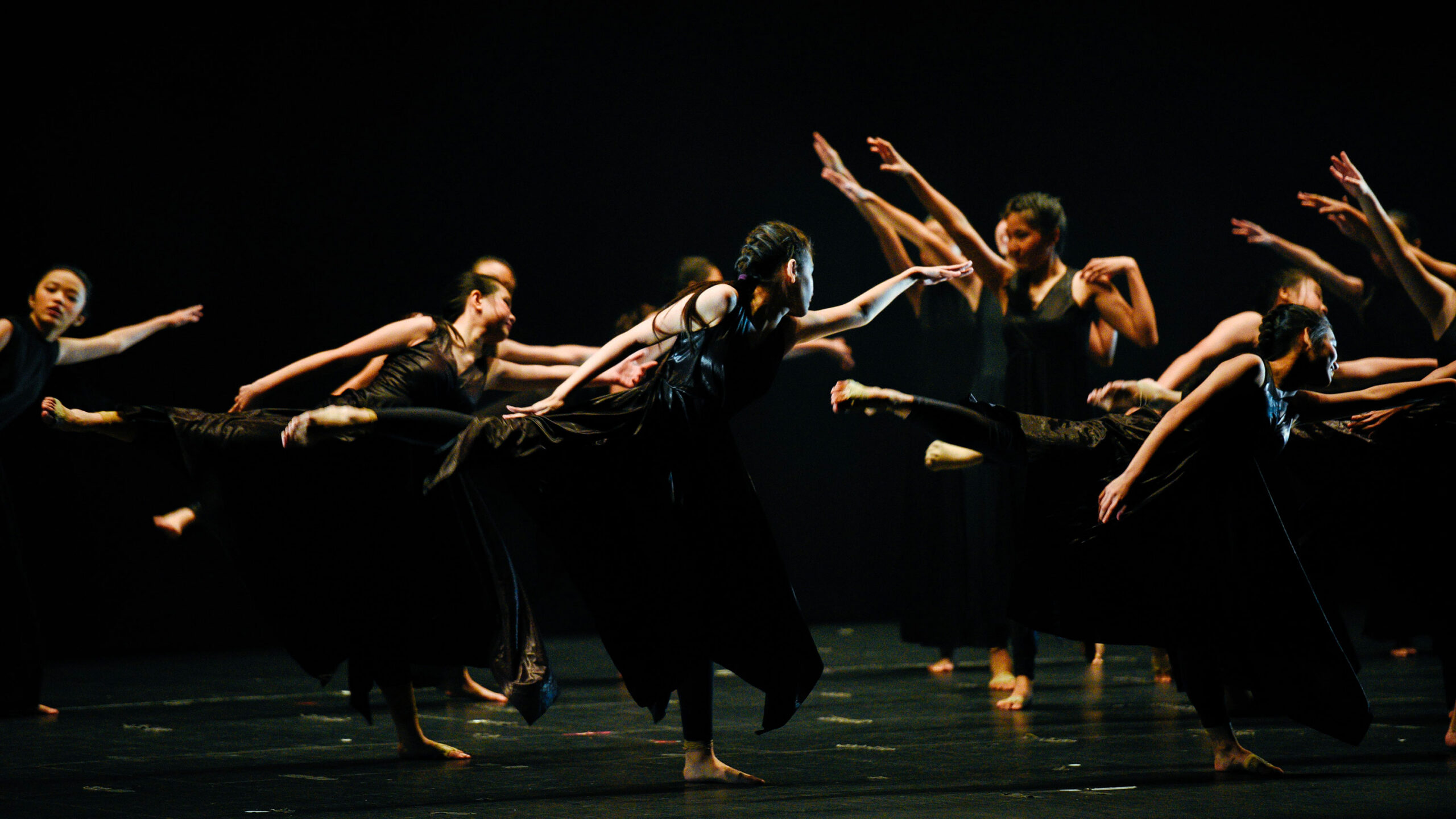 Spectacle de danse contemporaine, groupe de danseuses en robes noires sur scène