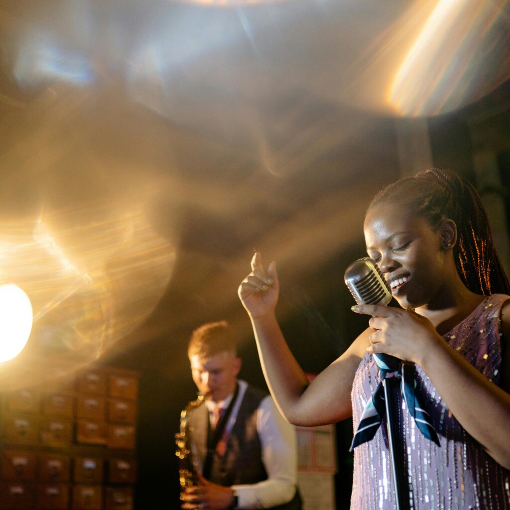 Chanteuse de jazz au microphone vintage sur scène, accompagnée d'un saxophoniste