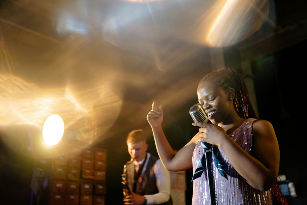 Chanteuse de jazz au microphone vintage sur scène, accompagnée d'un saxophoniste